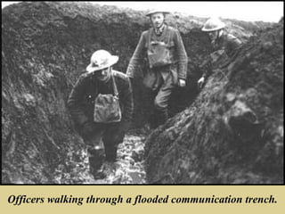 Officers walking through a flooded communication trench.
 