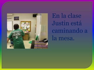 En la clase Justin está caminando a la mesa. 