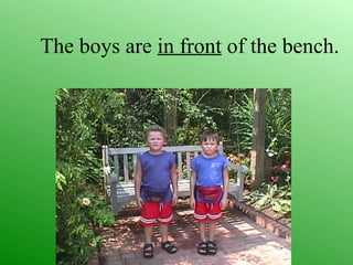 The boys are in front of the bench.